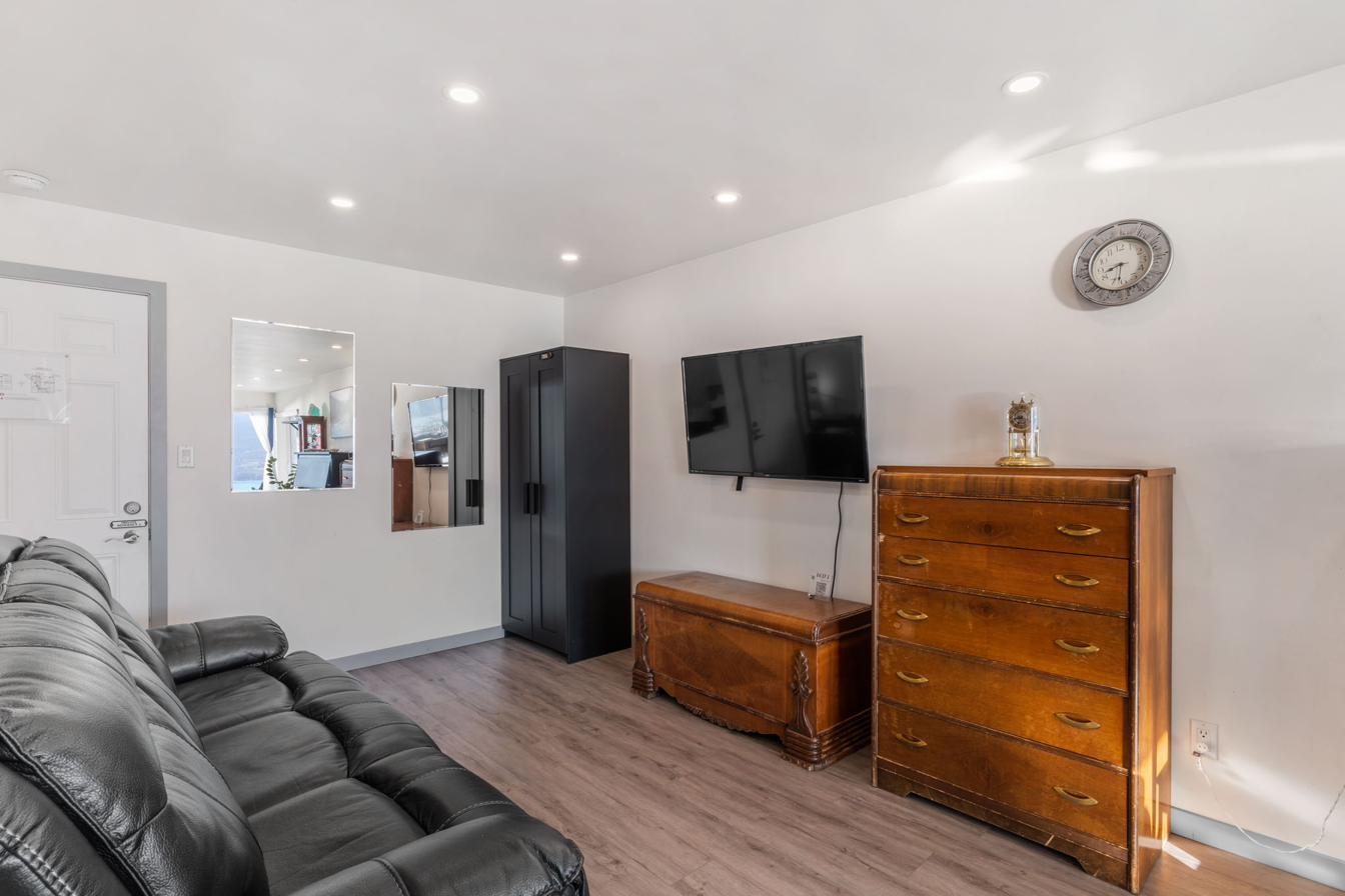 Living room with leather sofa, Smart TV, and natural light