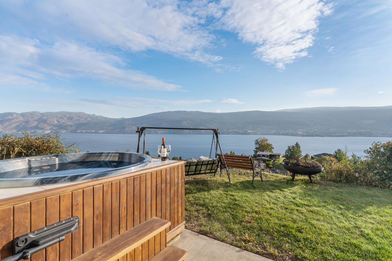 Patio area with hot tub and sweeping lake view